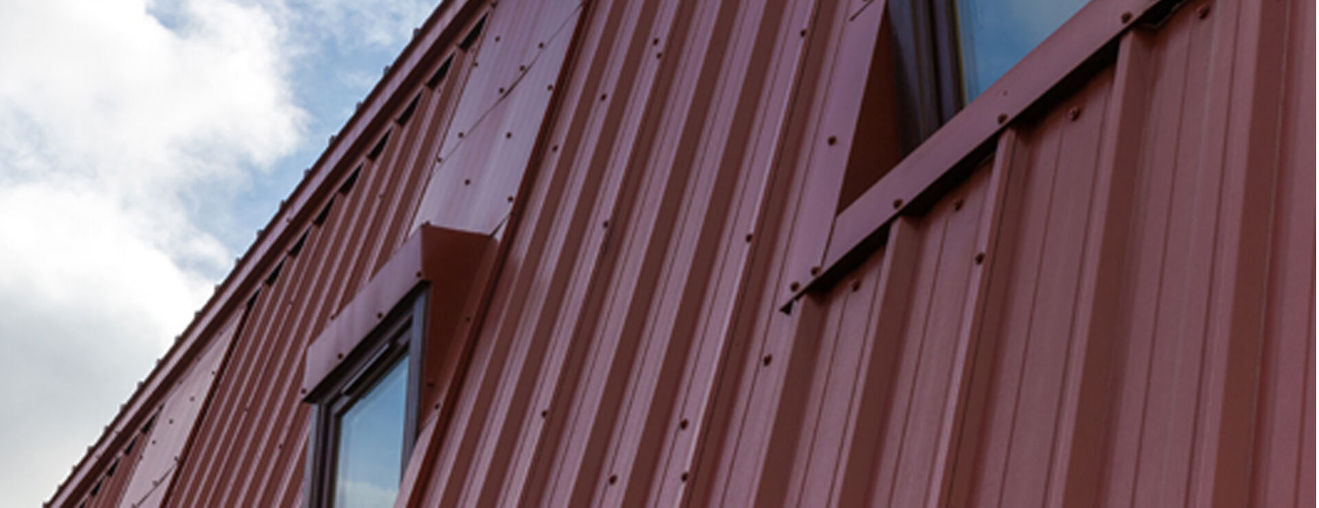 Red profiled metal cladding installed by Braedale Roofing